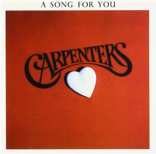 A red background features the Carpenters' name with an artistic heart symbol below.