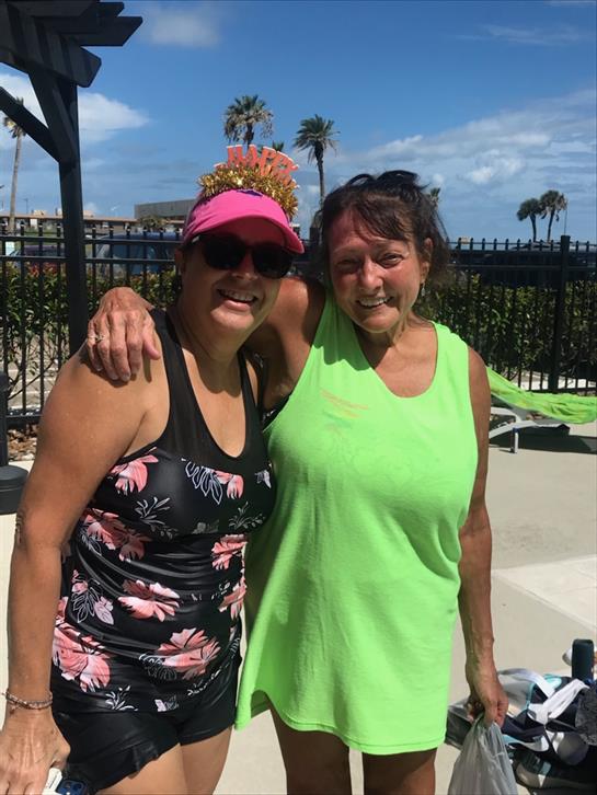Women dressed in swimwear take a joyful photo together at a California poolside.