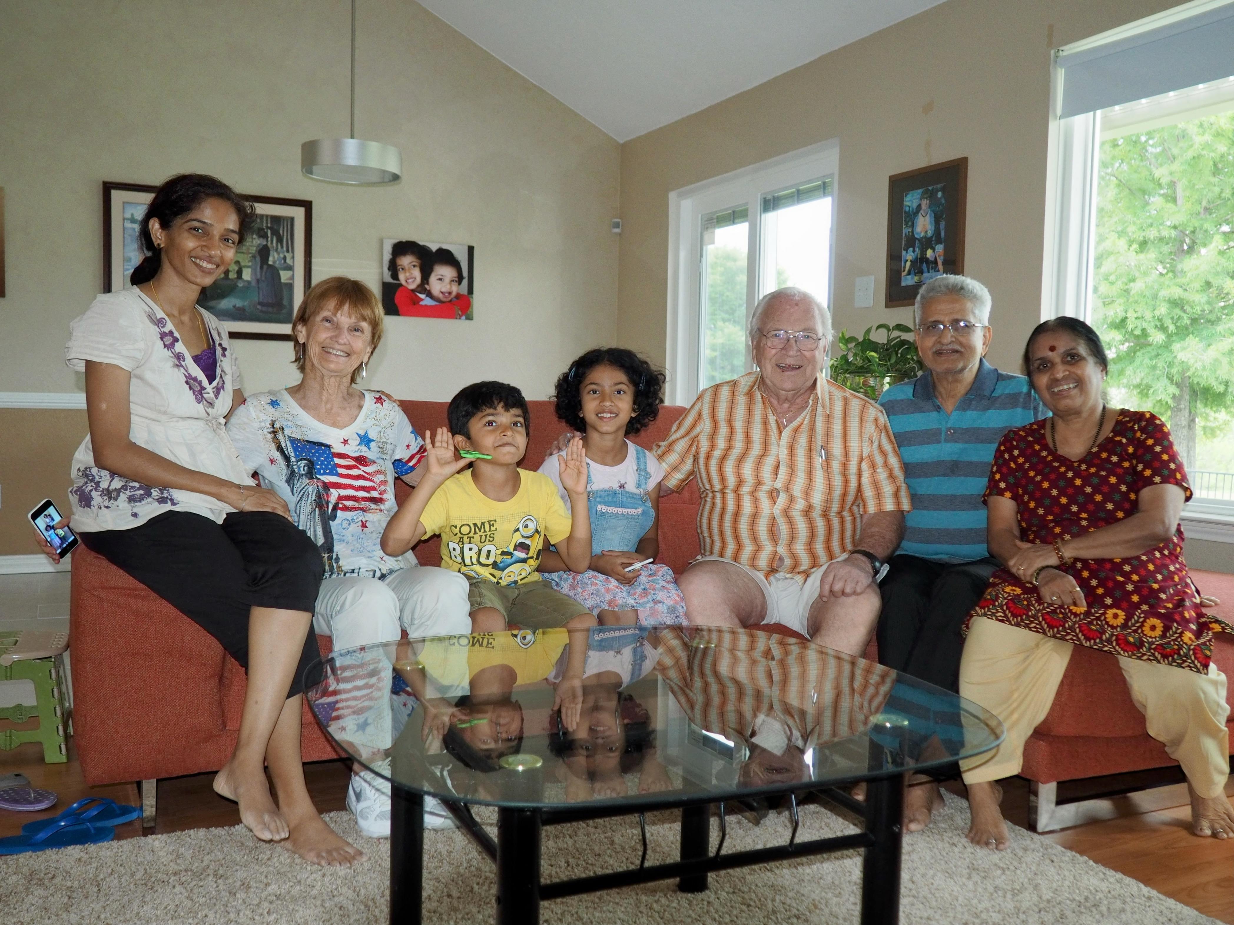 Several family members enjoy quality time together in a bright living room filled with laughter.