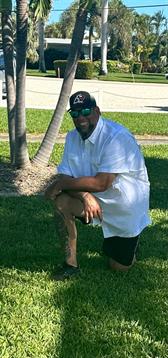 A man squatting on grass