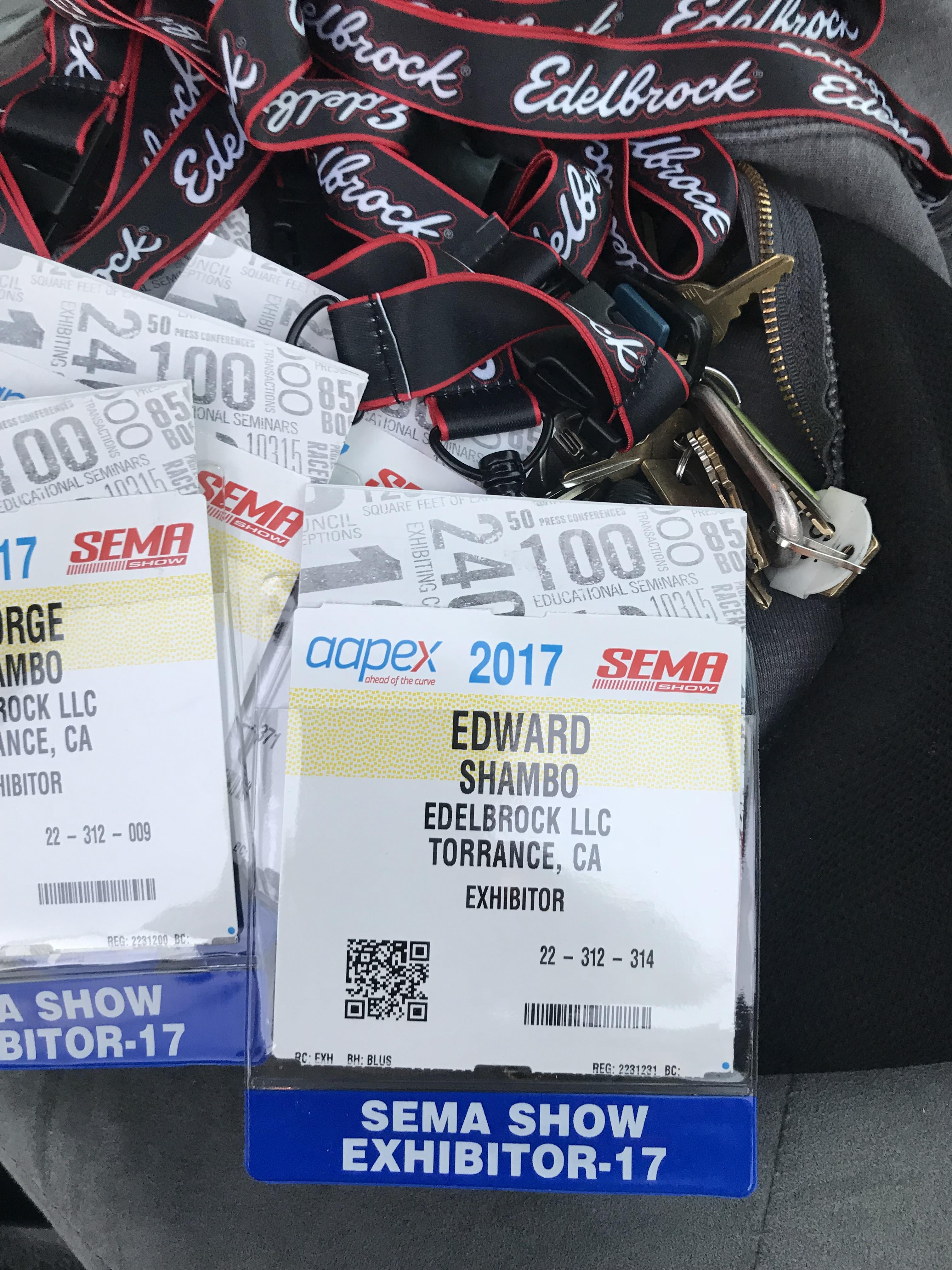 Multiple exhibitor badges from the 2017 SEMA Show showcasing attendee info on a surface.