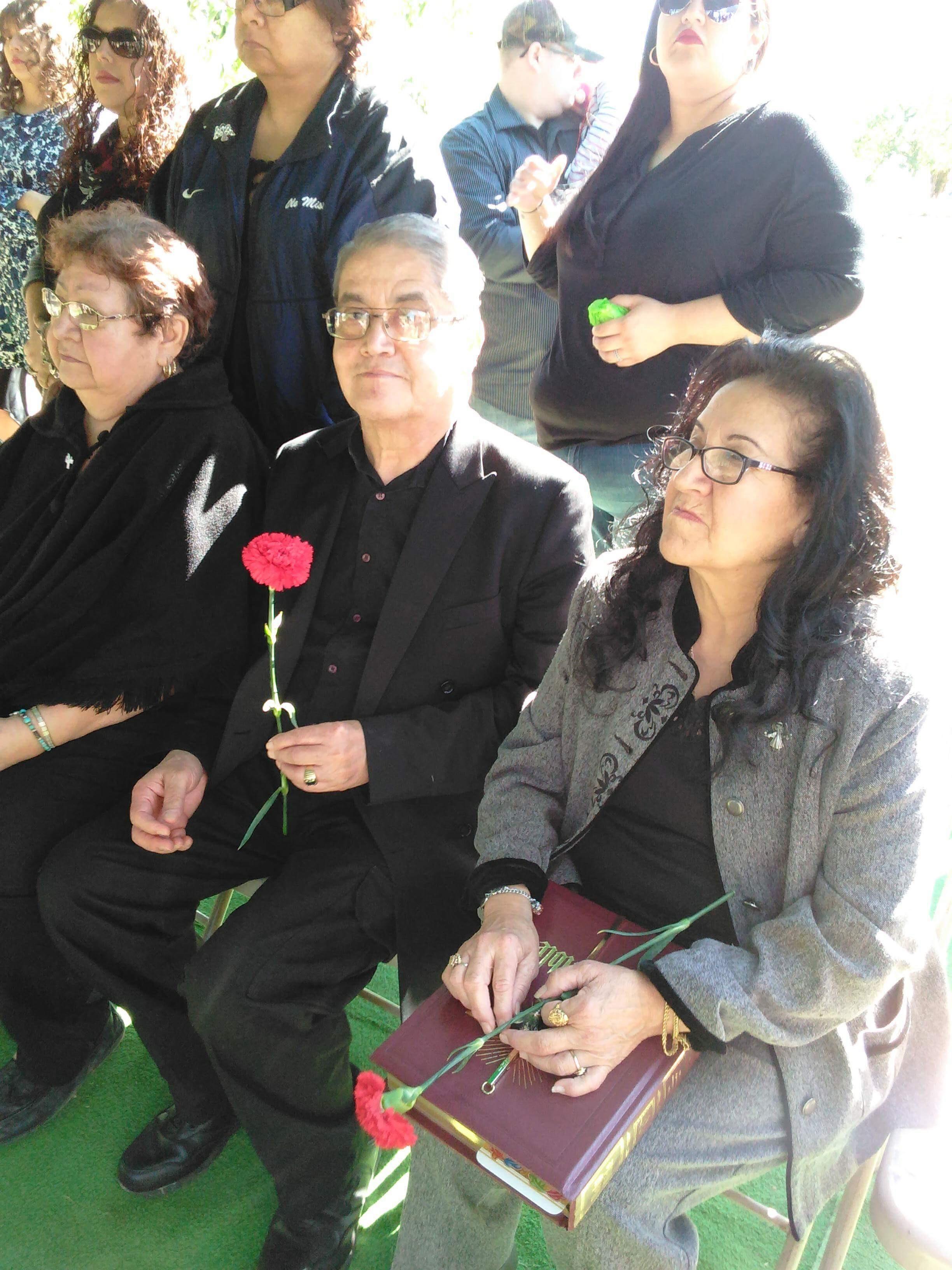 Attendees hold roses, solemnly remembering a loved one at the memorial service.