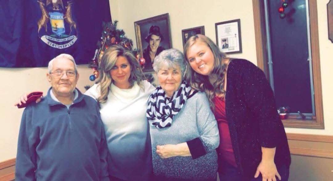 A cheerful group of four poses together, celebrating togetherness during a winter gathering.