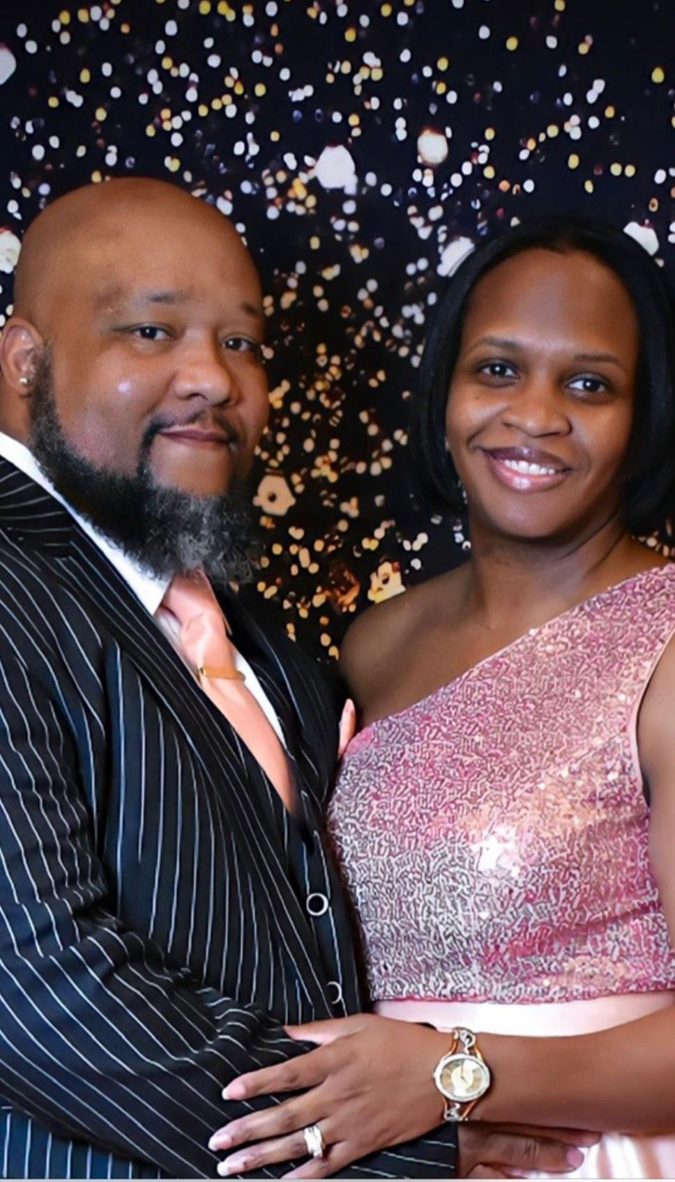 A well-dressed couple poses together, showing joy and elegance at a festive occasion.
