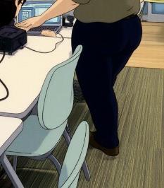 A person is focused on their work at a desk with a computer in a modern office environment.