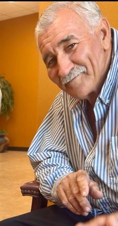 A man with a mustache and a mustache wearing a striped shirt