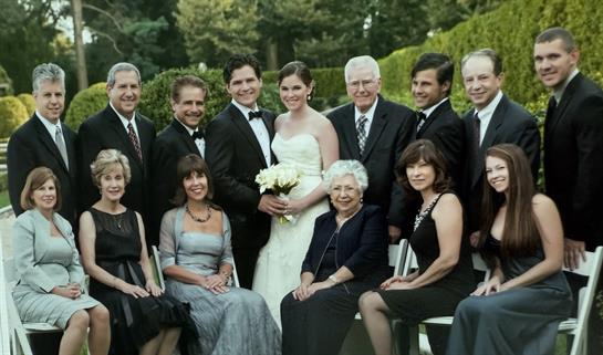 Group of happy guests gathered for a wedding in a beautiful garden, showcasing joy and togetherness.