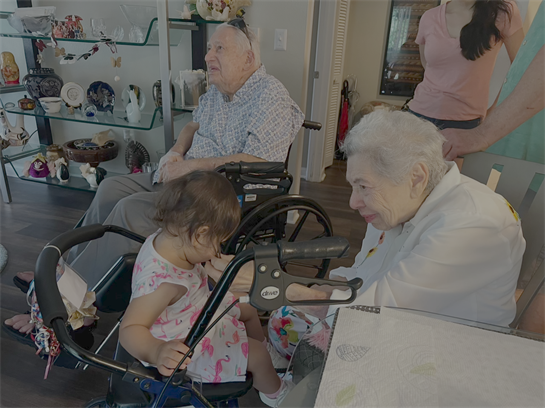 An elderly couple enjoys playful moments with a toddler in a bright, inviting living space.