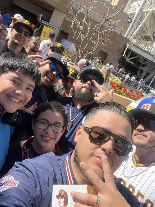 Friends gather together for a joyful selfie outside the stadium during a baseball event.