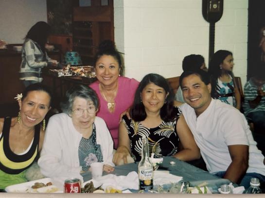 Five family members enjoy a meal and celebrate their bond in a cozy restaurant setting.