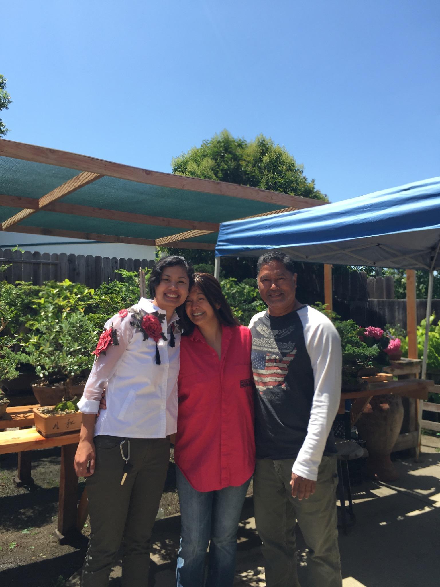 Friends enjoy each other’s company in a community garden under a blue sky.