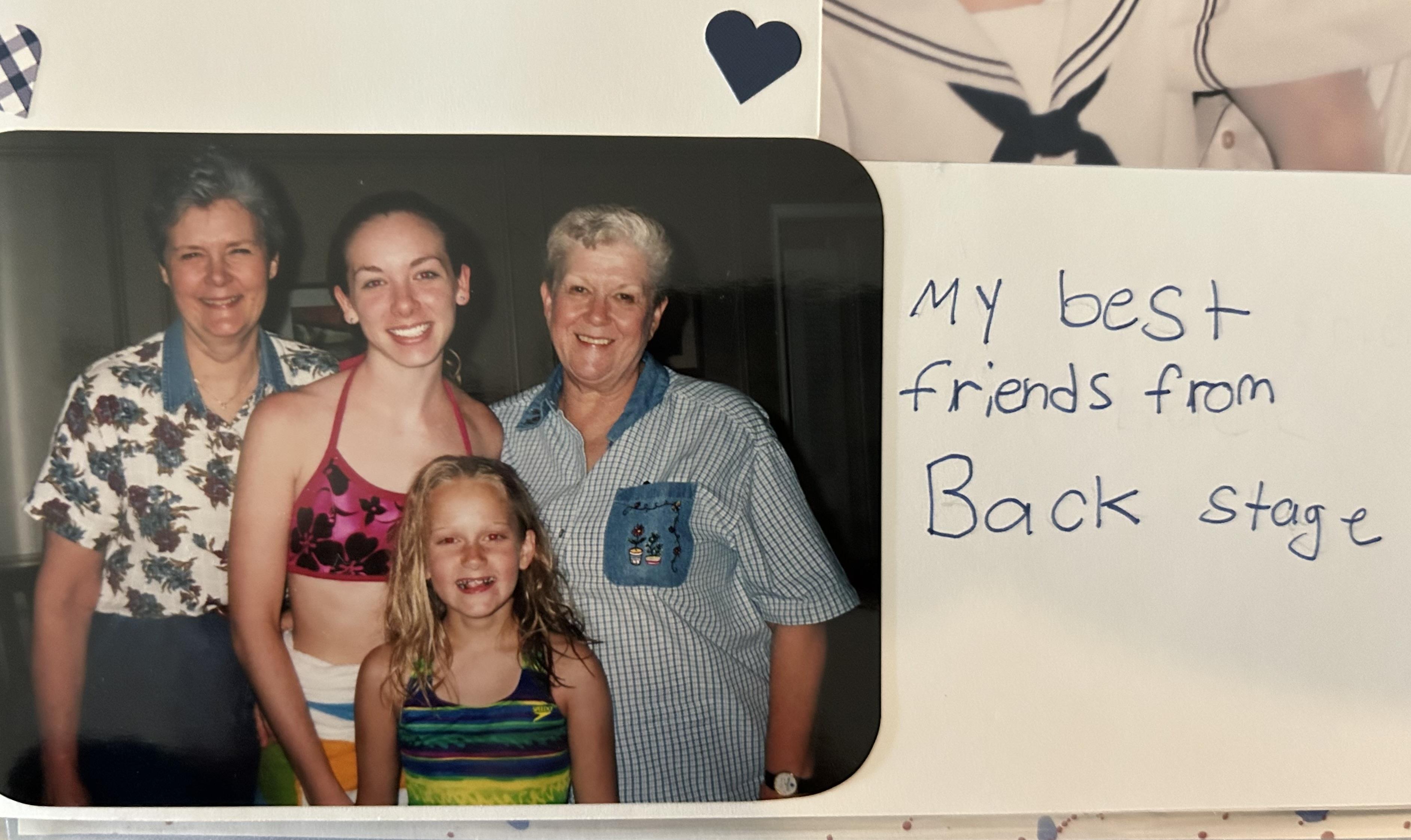 Four friends gather together smiling while posing backstage at a summer event.