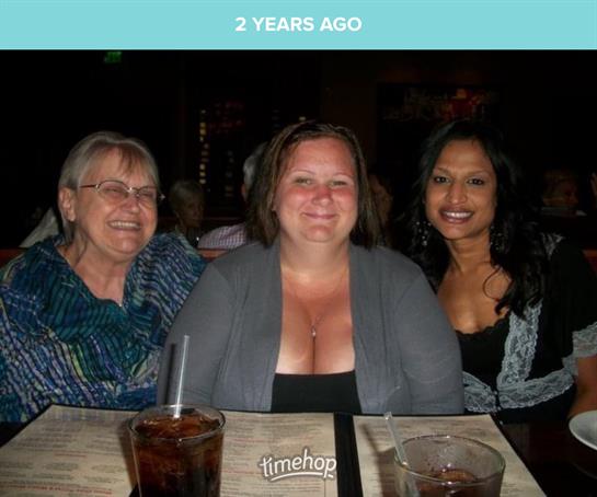 Three women gather at a restaurant, smiling and celebrating their friendship over drinks.