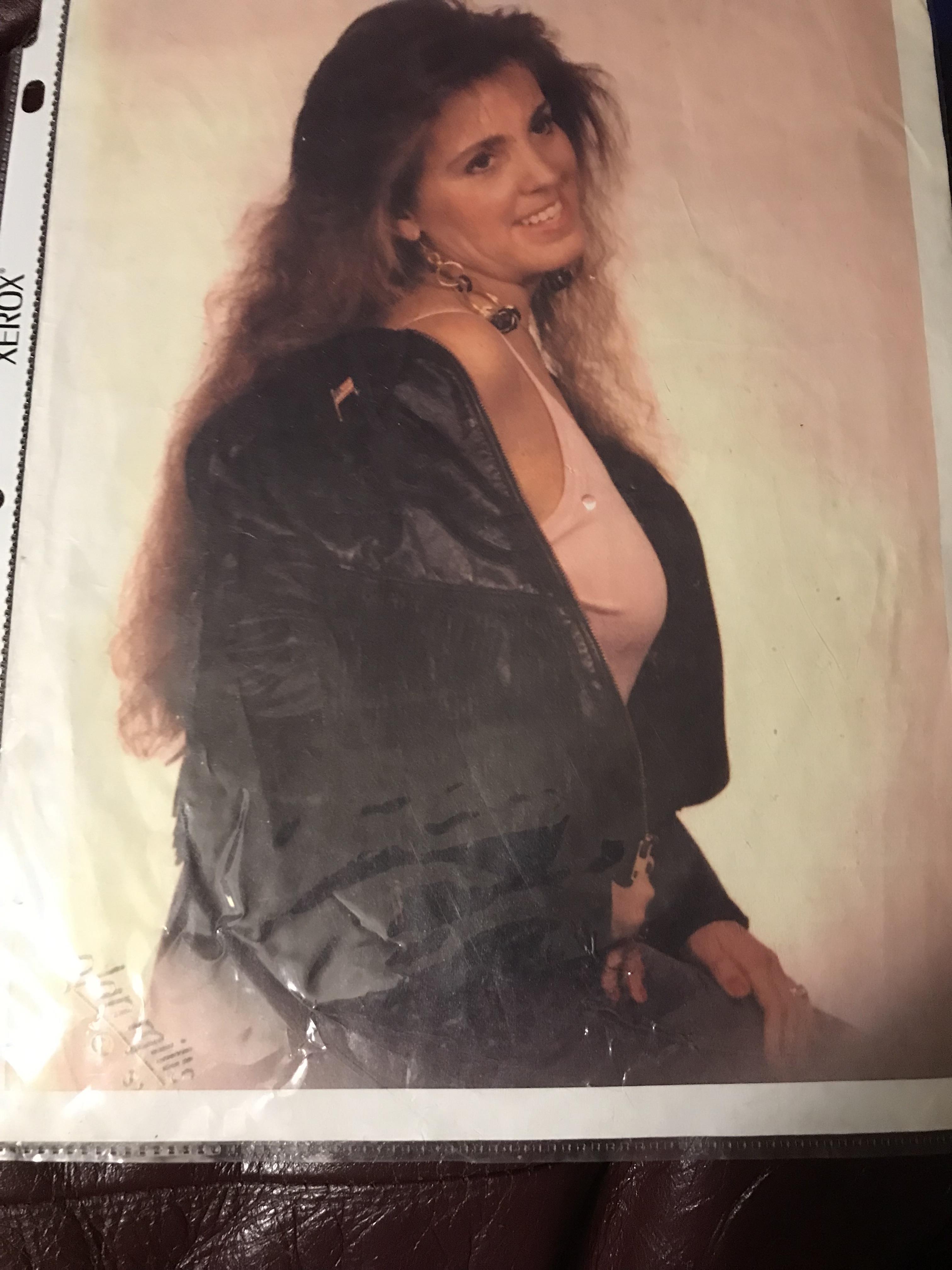 A young woman showcases a fashionable outfit, smiling brightly while posing in a studio.