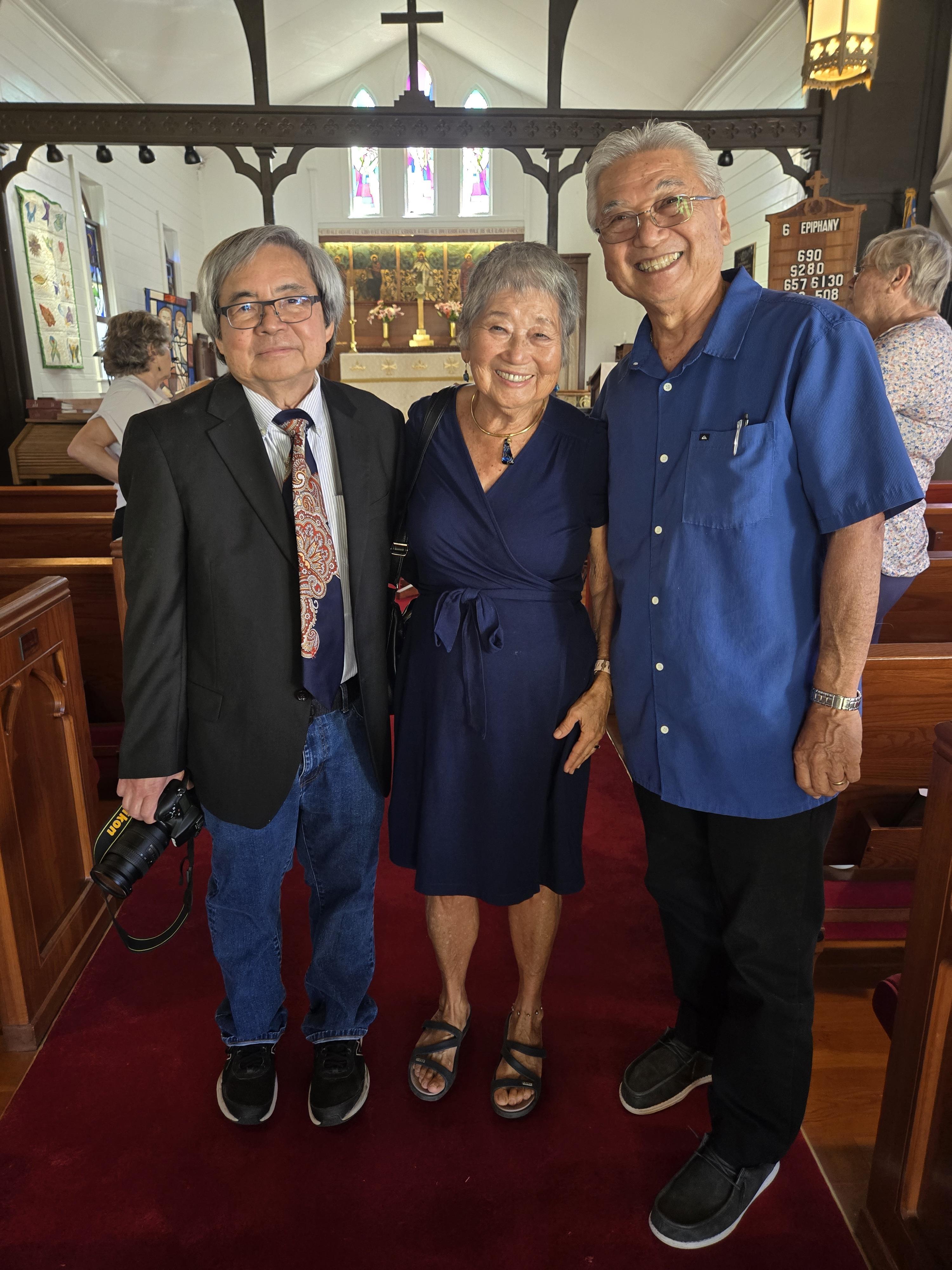 Friends smile together inside a church, dressed smartly for a memorable gathering.