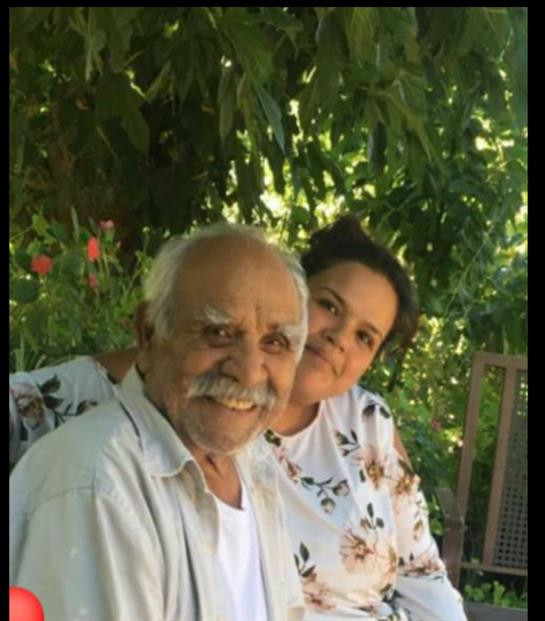 Cheerful relatives smile and share a moment together in a lush garden filled with blooming flowers.