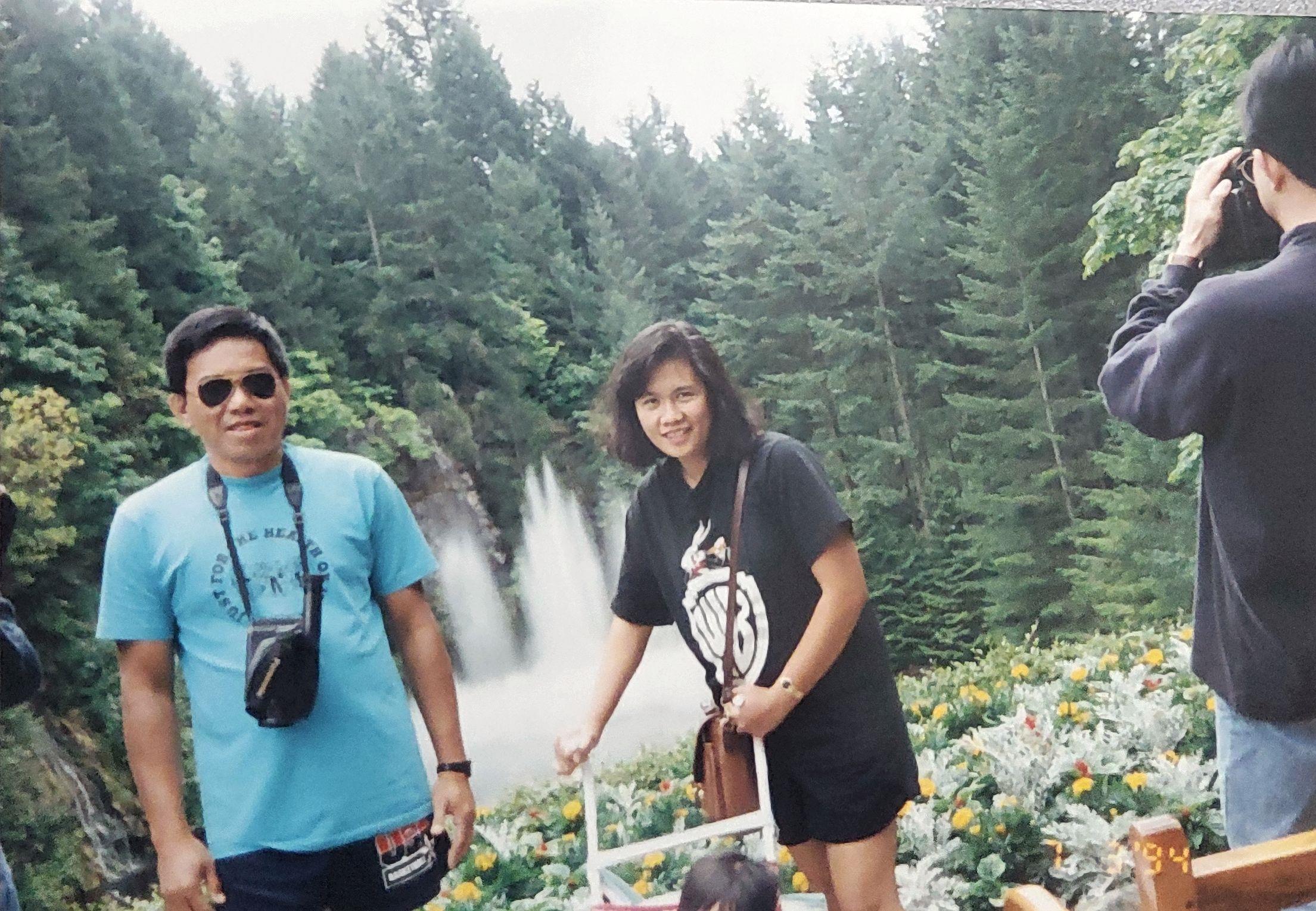 Friends explore a beautiful waterfall, enjoying the natural surroundings and taking pictures.