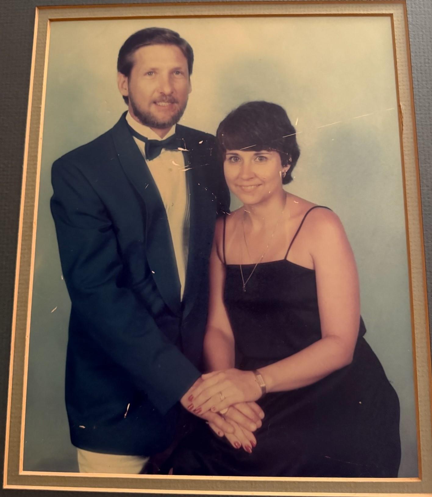 Couple in formal wear smiles together at an elegant event, capturing a cherished moment.