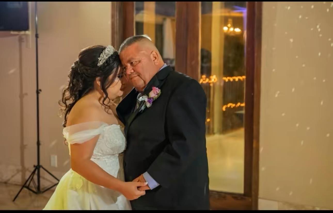 A bride and groom share a romantic dance, surrounded by a warm atmosphere of love and celebration.