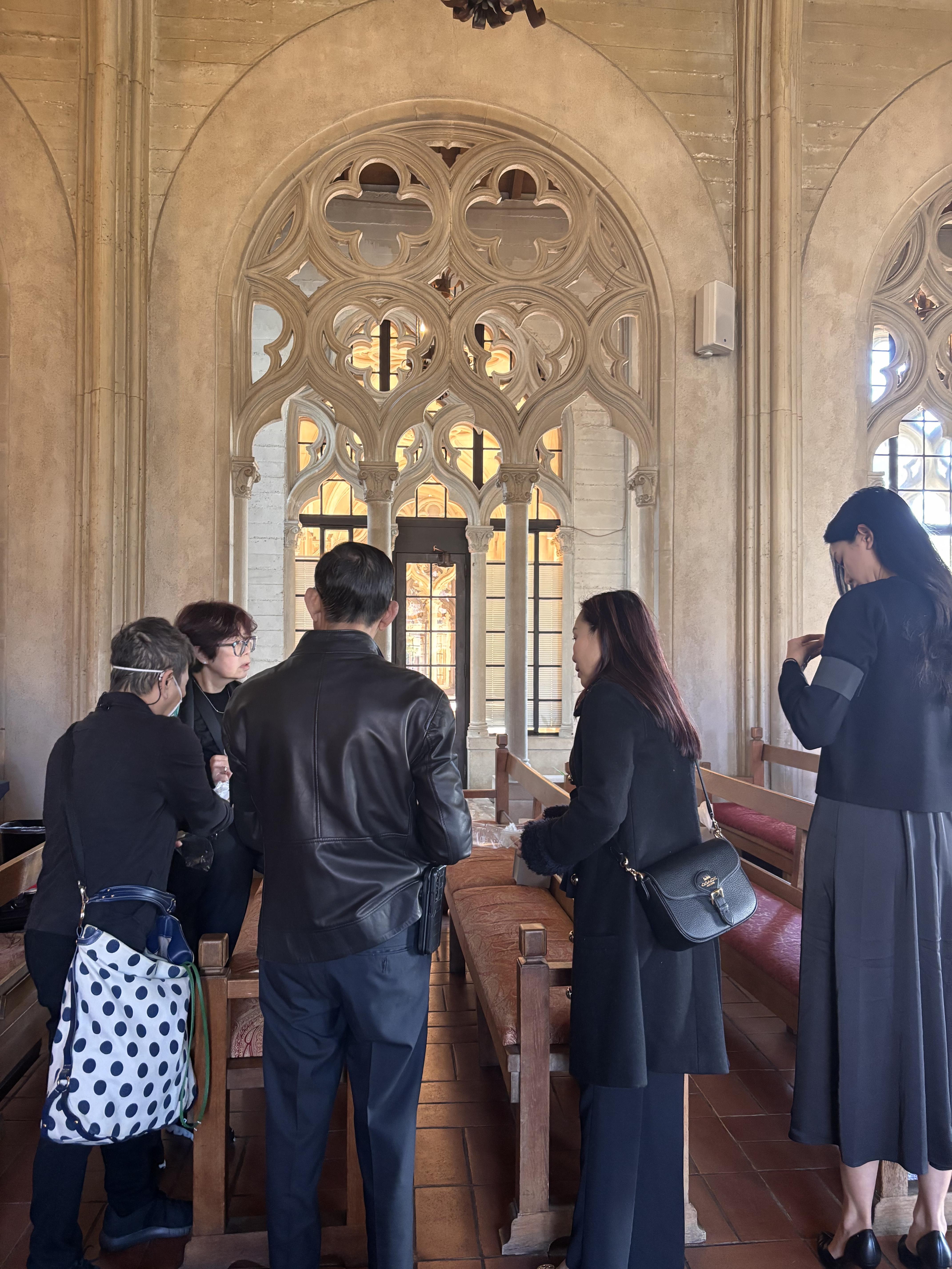 Visitors admire intricate architectural details in a historic space while engaged in conversation.