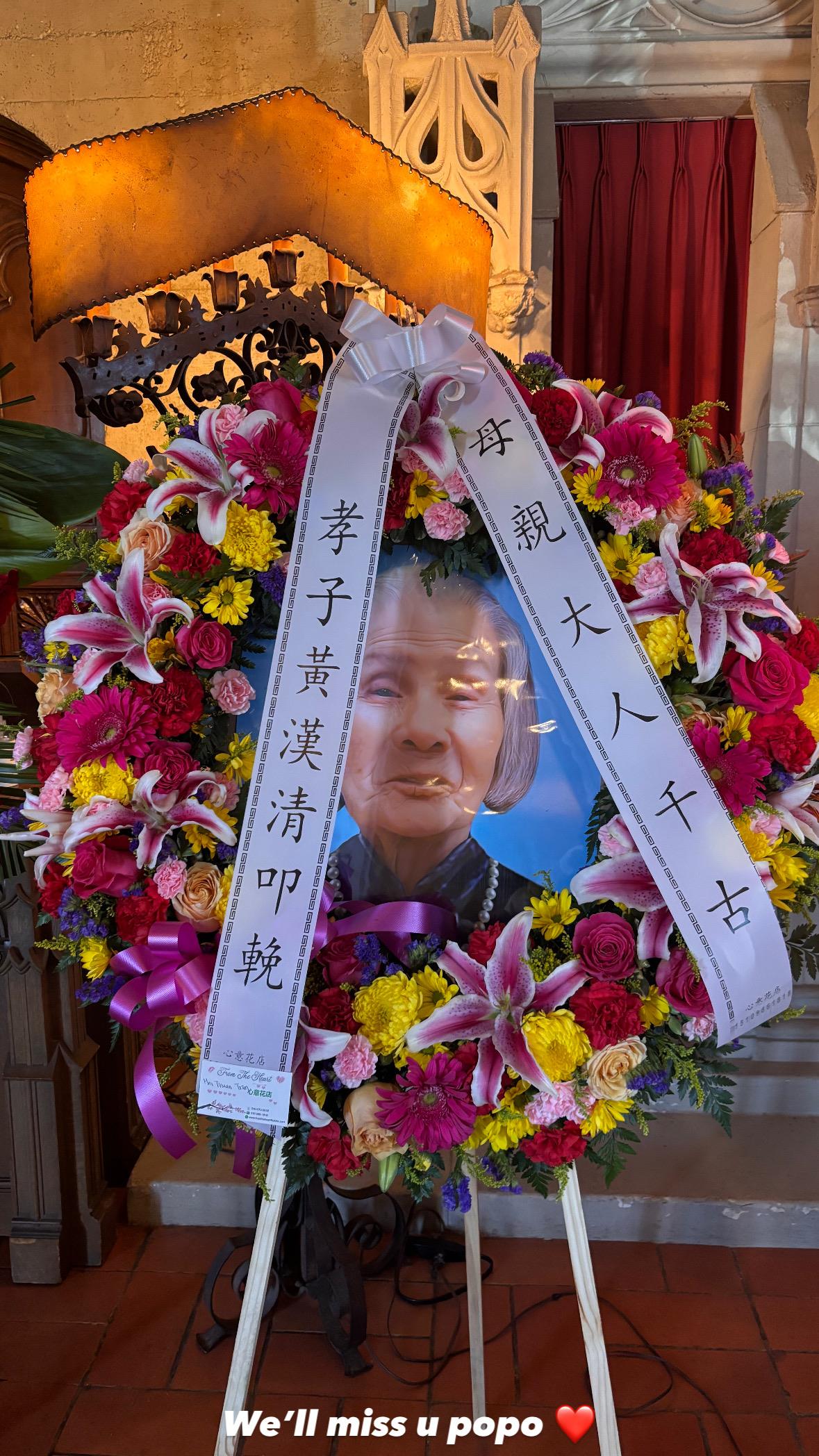 A vibrant floral tribute displays a portrait, honoring a cherished family member.