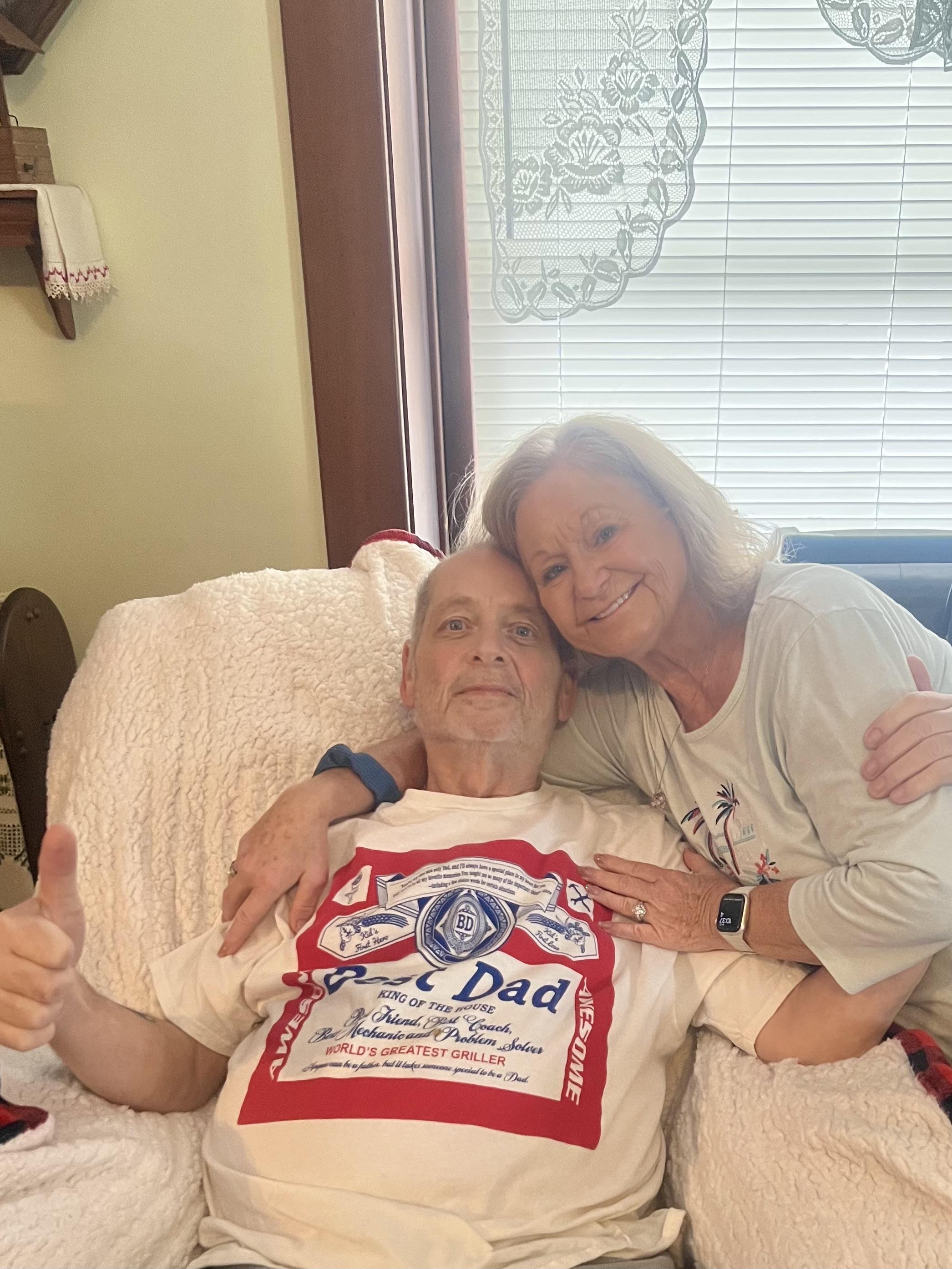 A daughter shares a warm embrace with her father at home, enjoying a cheerful family gathering.