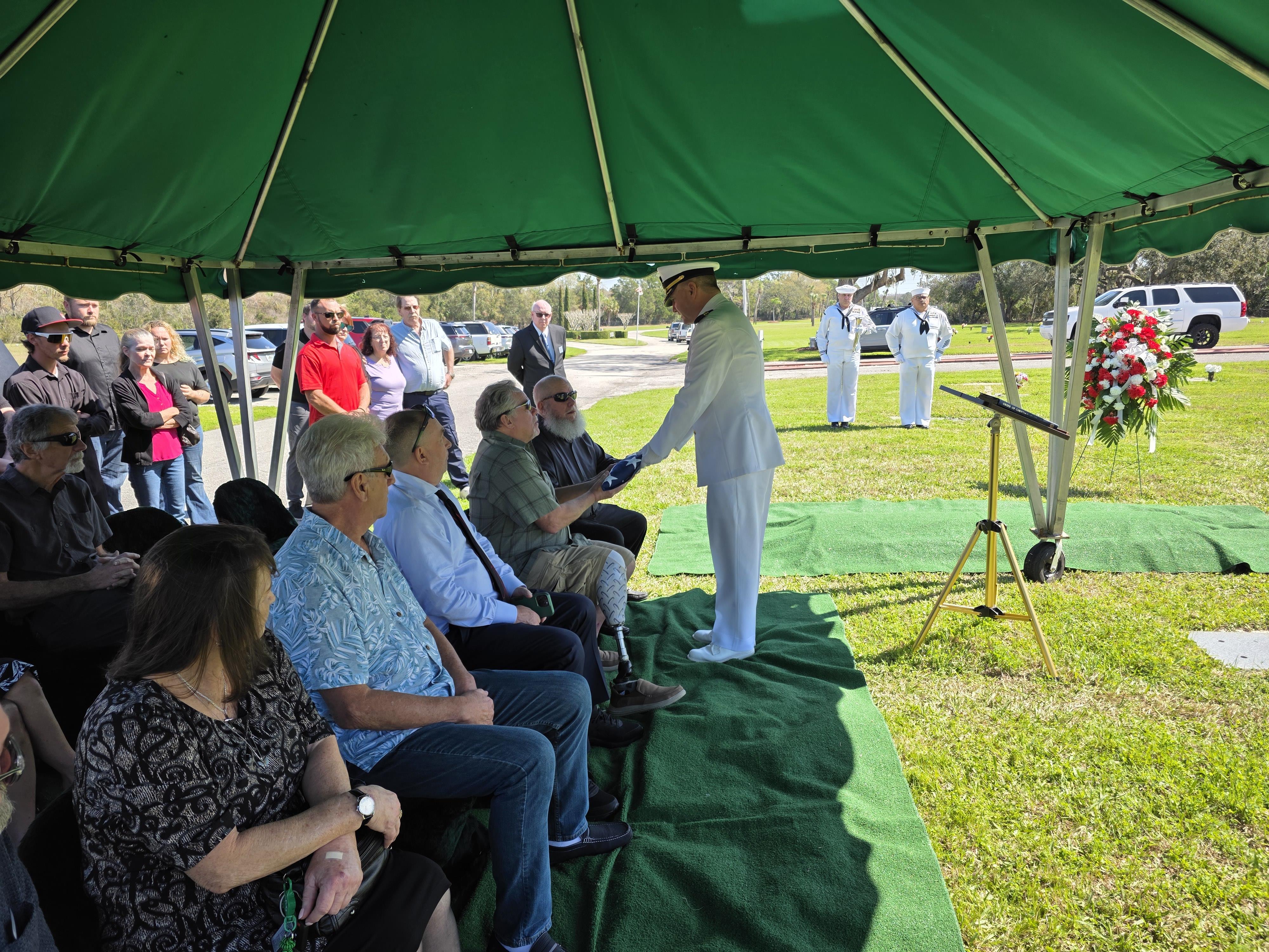 Community members gathered to honor veterans during a commemorative ceremony outside.