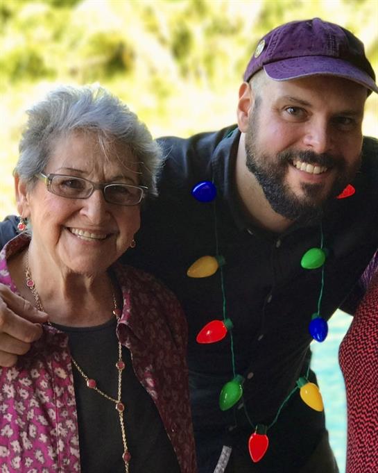 Two smiling individuals pose closely together, showcasing a warm family connection and celebration.