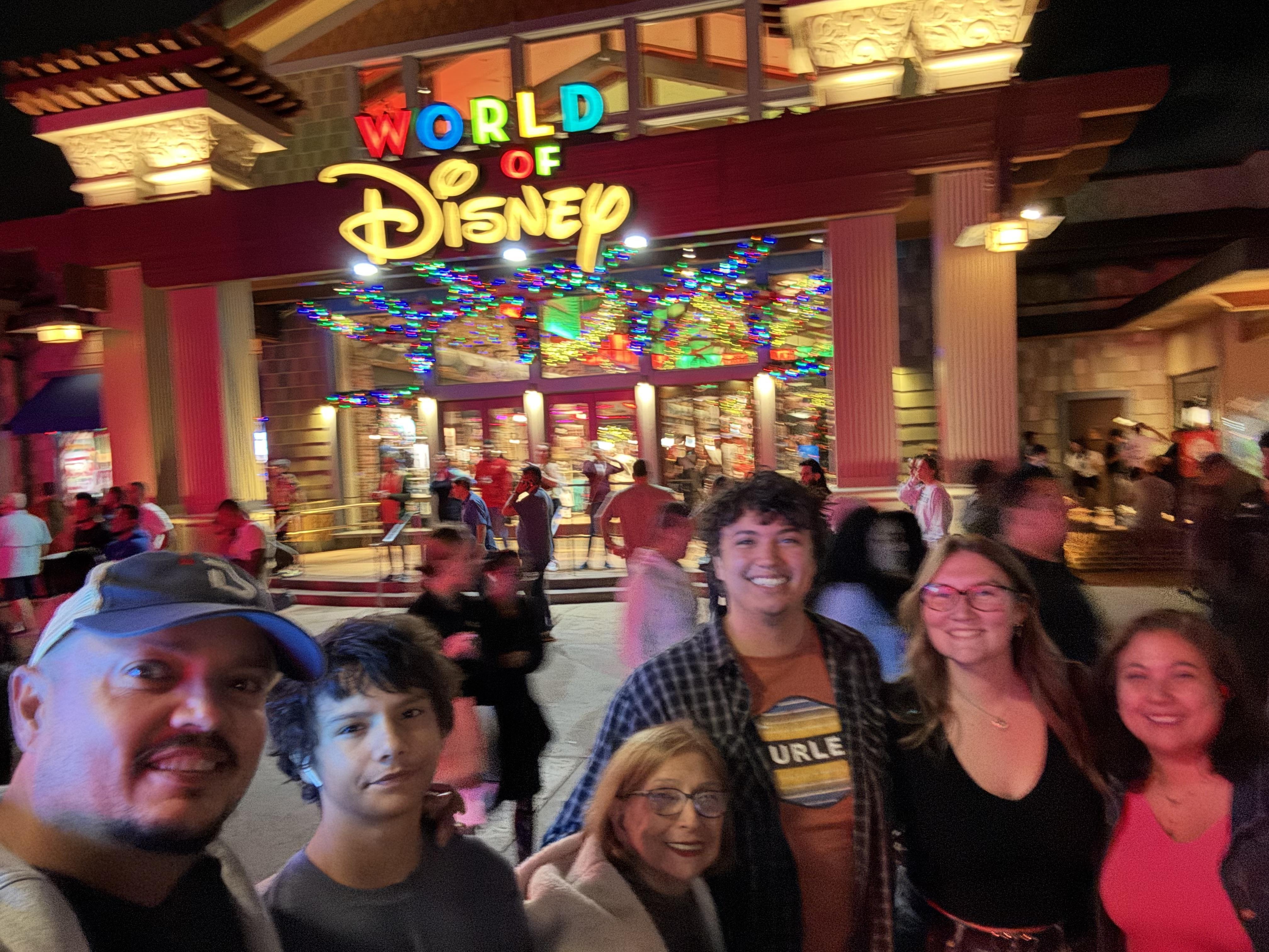Family poses for a memorable photo outside the colorful World of Disney store.