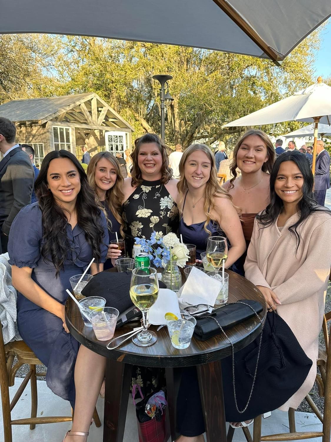 Friends gather at a table, sharing drinks, laughter, and stories in a lively setting.