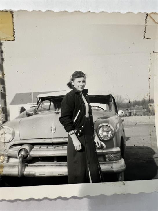 A woman standing in front of a car