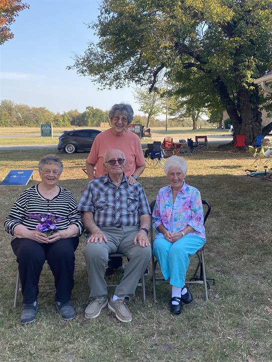 A group of people sitting in chairs outside