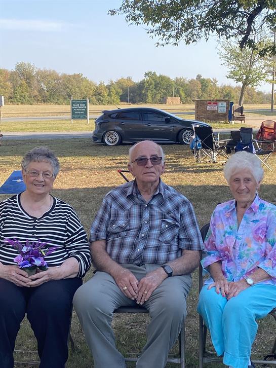 A group of people sitting in chairs outside