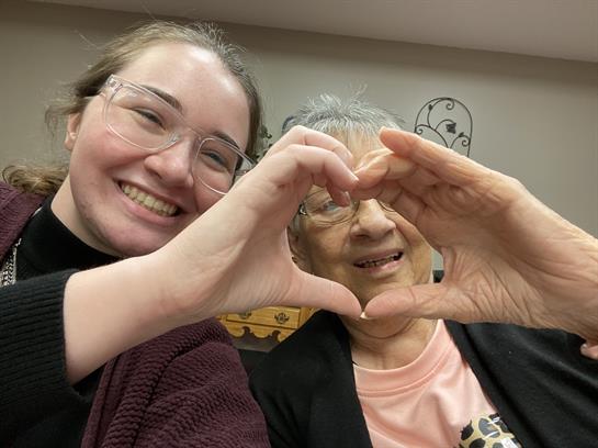 Two women making a heart with their hands