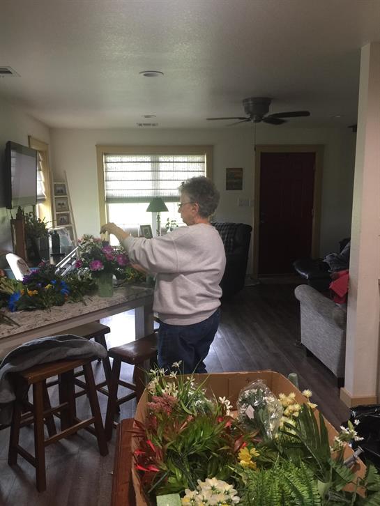 A woman standing in a room with a box of flowers
