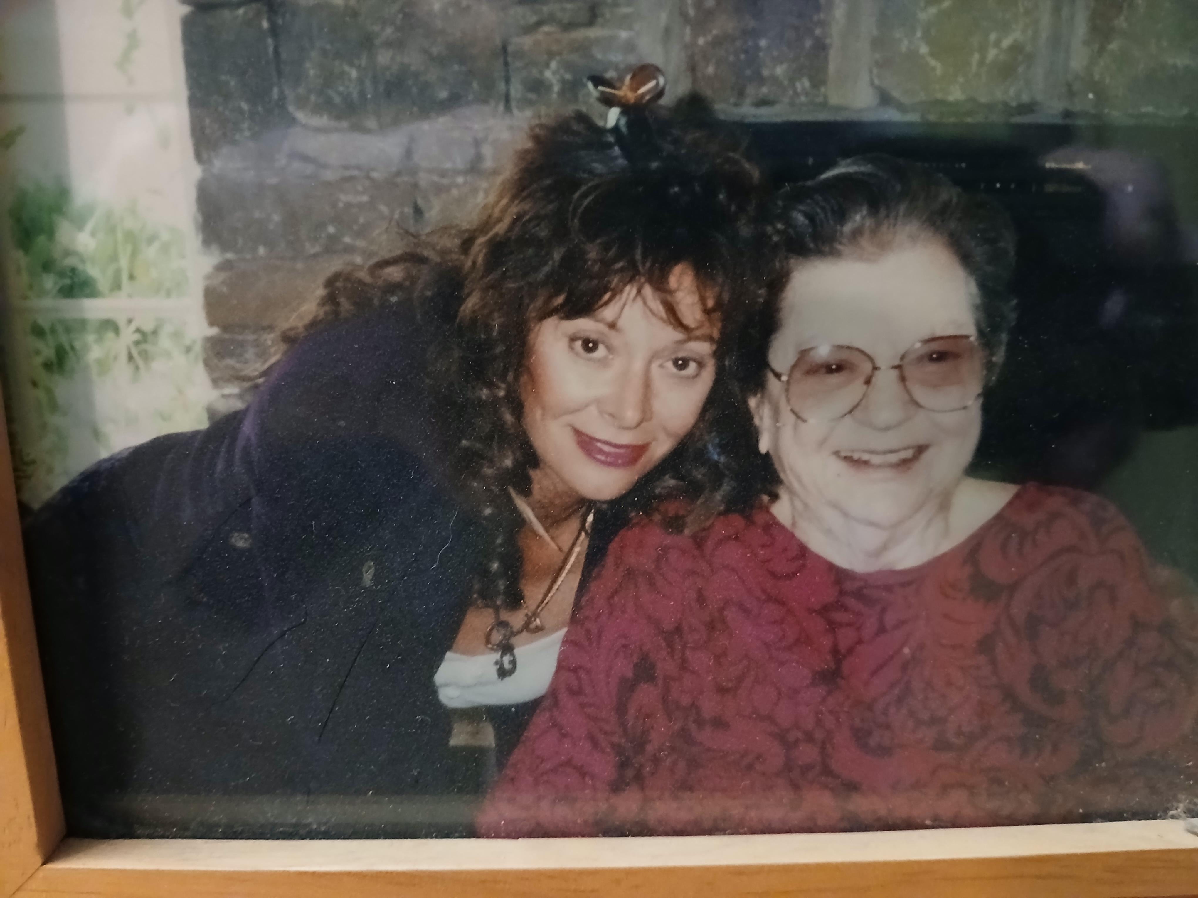 Two women share a joyful moment together in a warm, intimate setting with soft lighting.