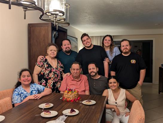 A joyful family reunion with loved ones enjoying cake and sharing laughter around a table.