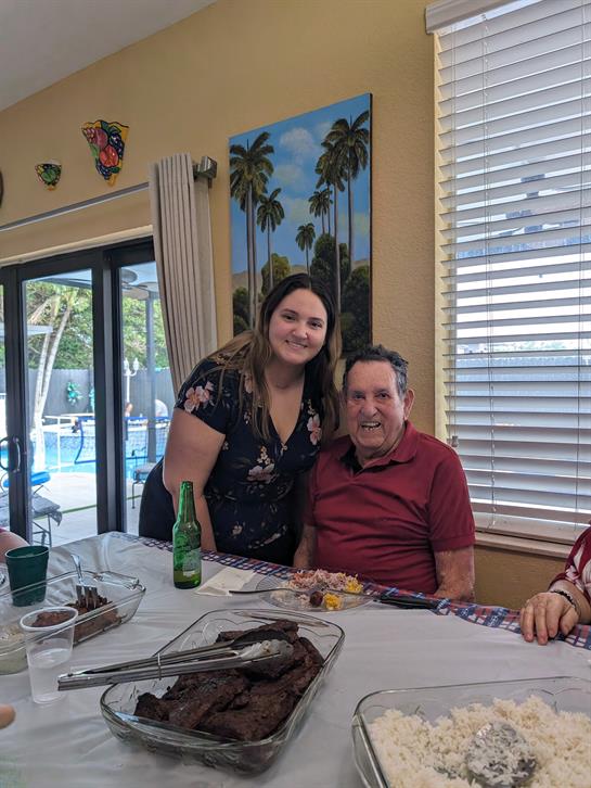 Friends and family enjoy a festive gathering with a colorful meal and laughter near a swimming pool.