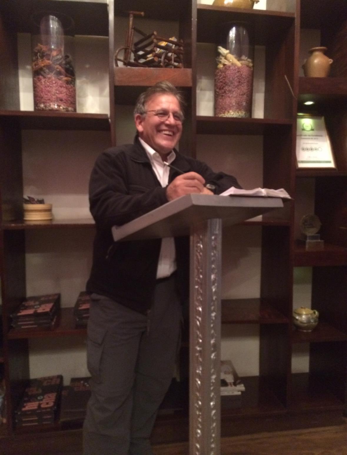 Individual enthusiastically delivers a talk to an audience in a charming, intimate setting.