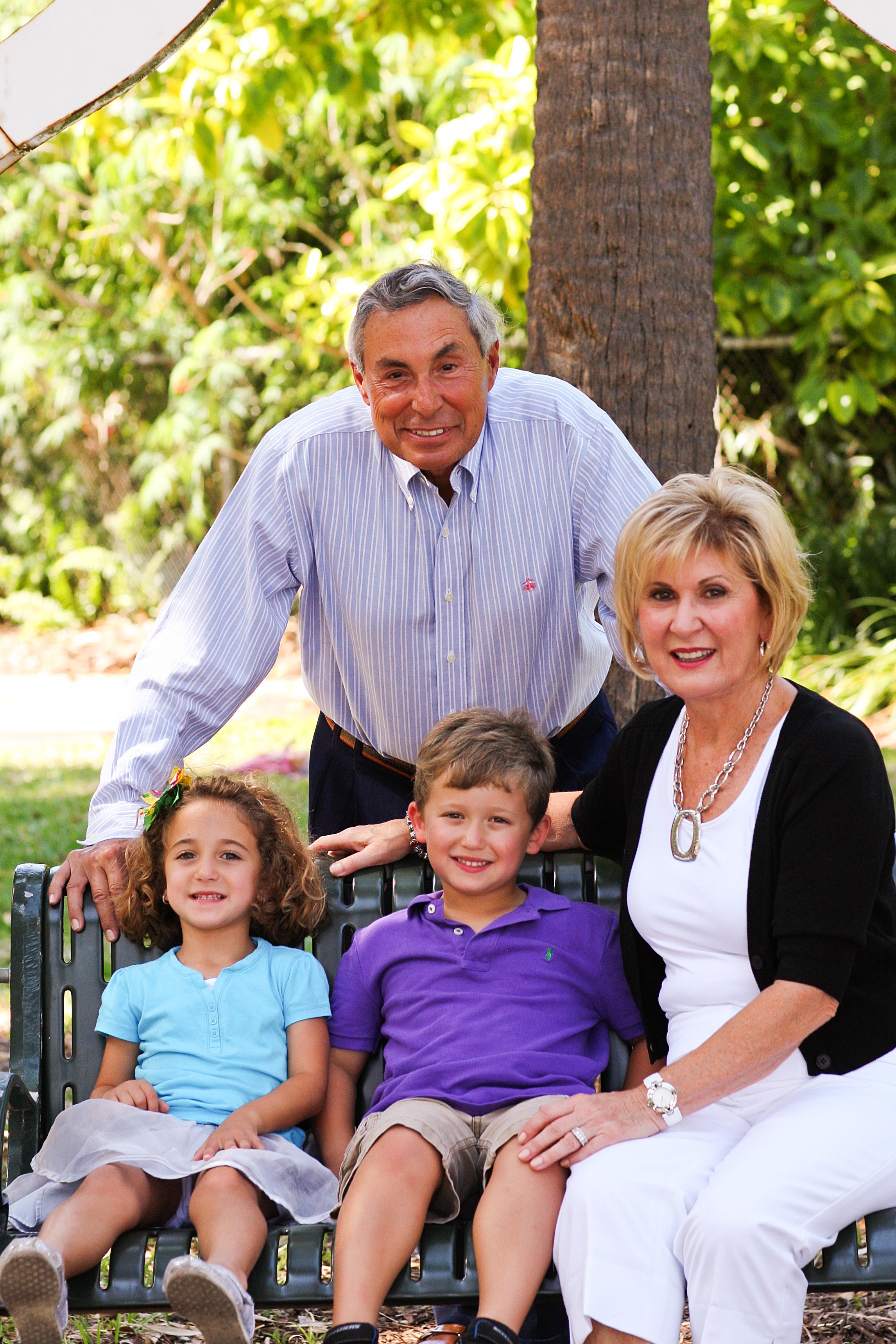 A happy family sits on a bench in a lush park, showcasing their bond and joy.