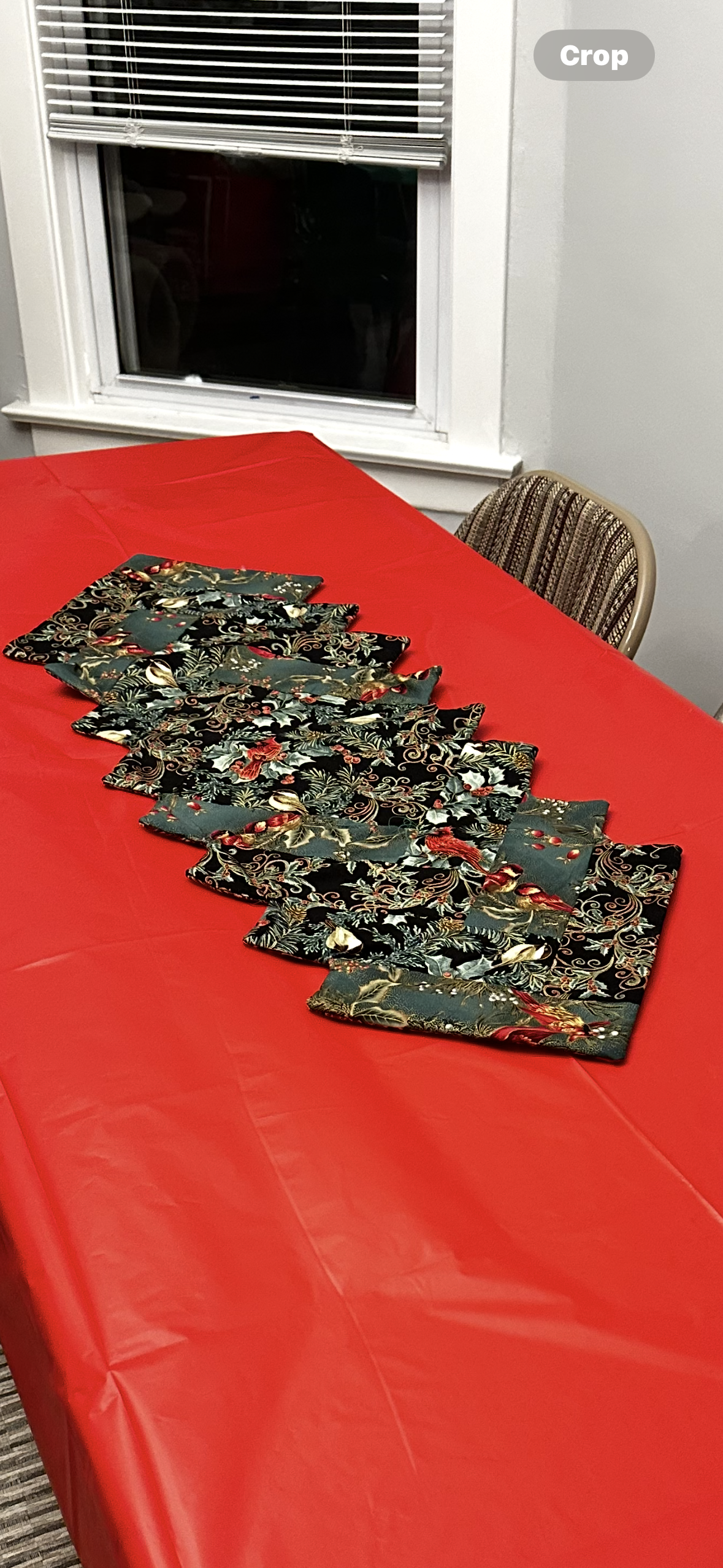 Table is adorned with decorative cloths on a vibrant red surface in a comfortable room.
