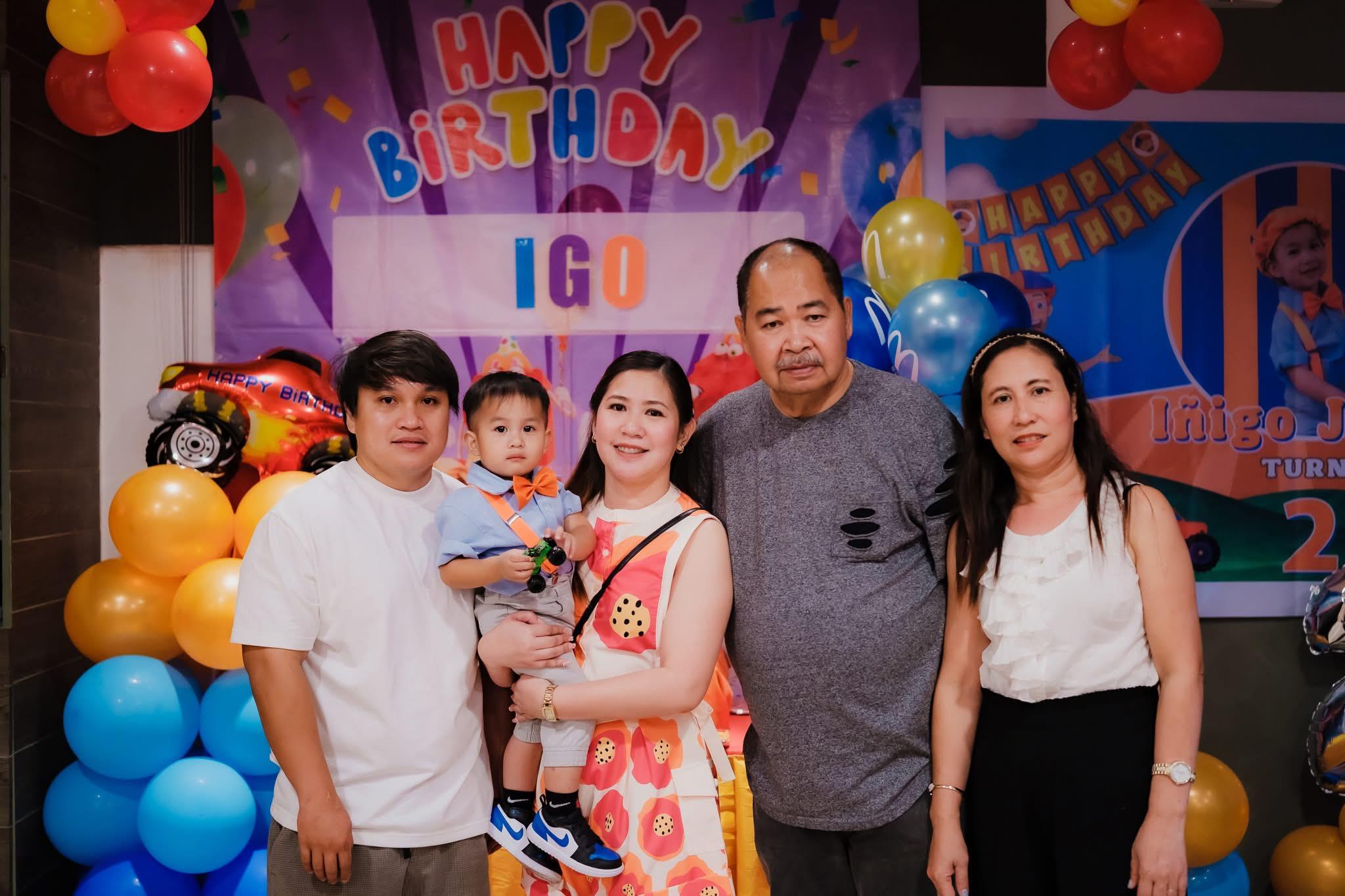 Family gathers joyfully to celebrate a child's birthday with colorful decorations and smiles.