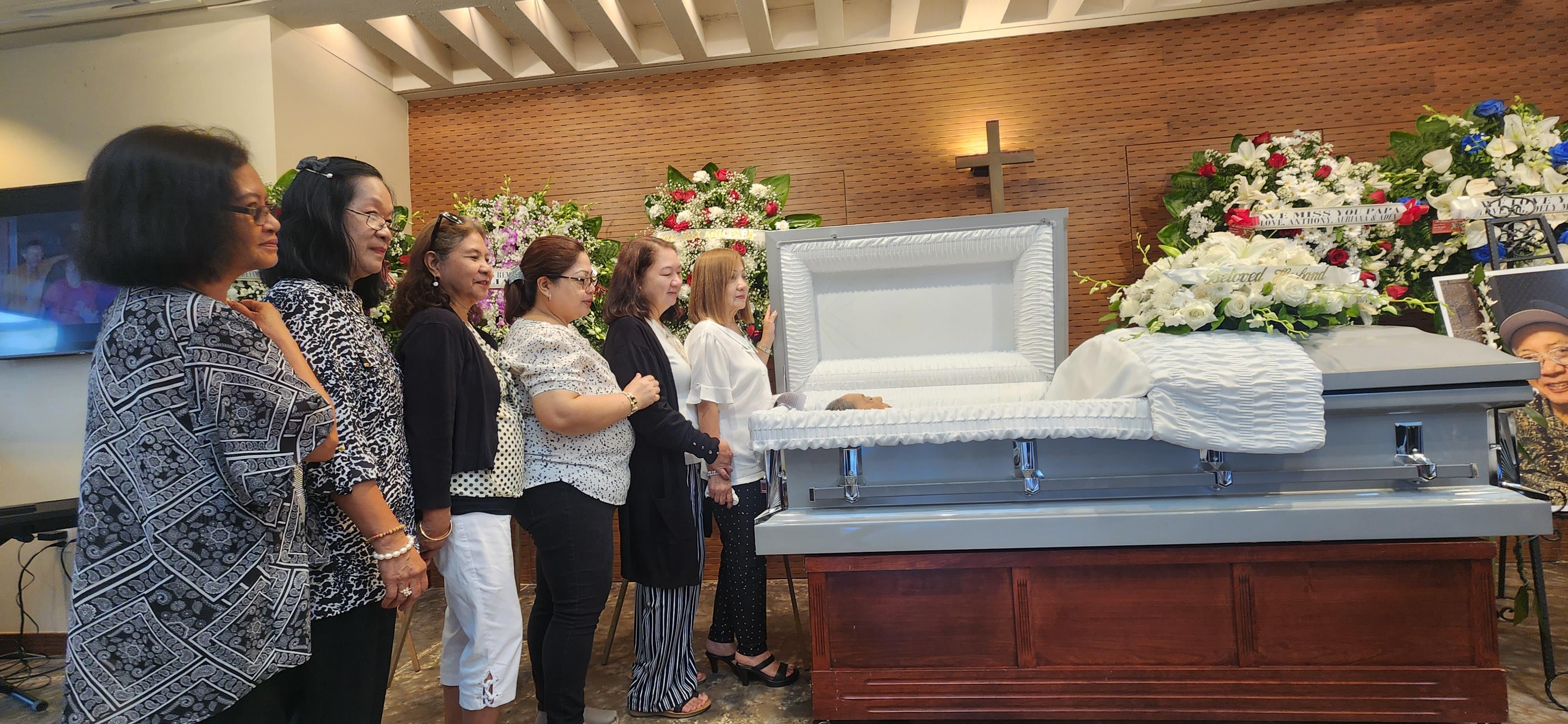 Family gathers to pay their respects during a somber funeral service in a chapel.