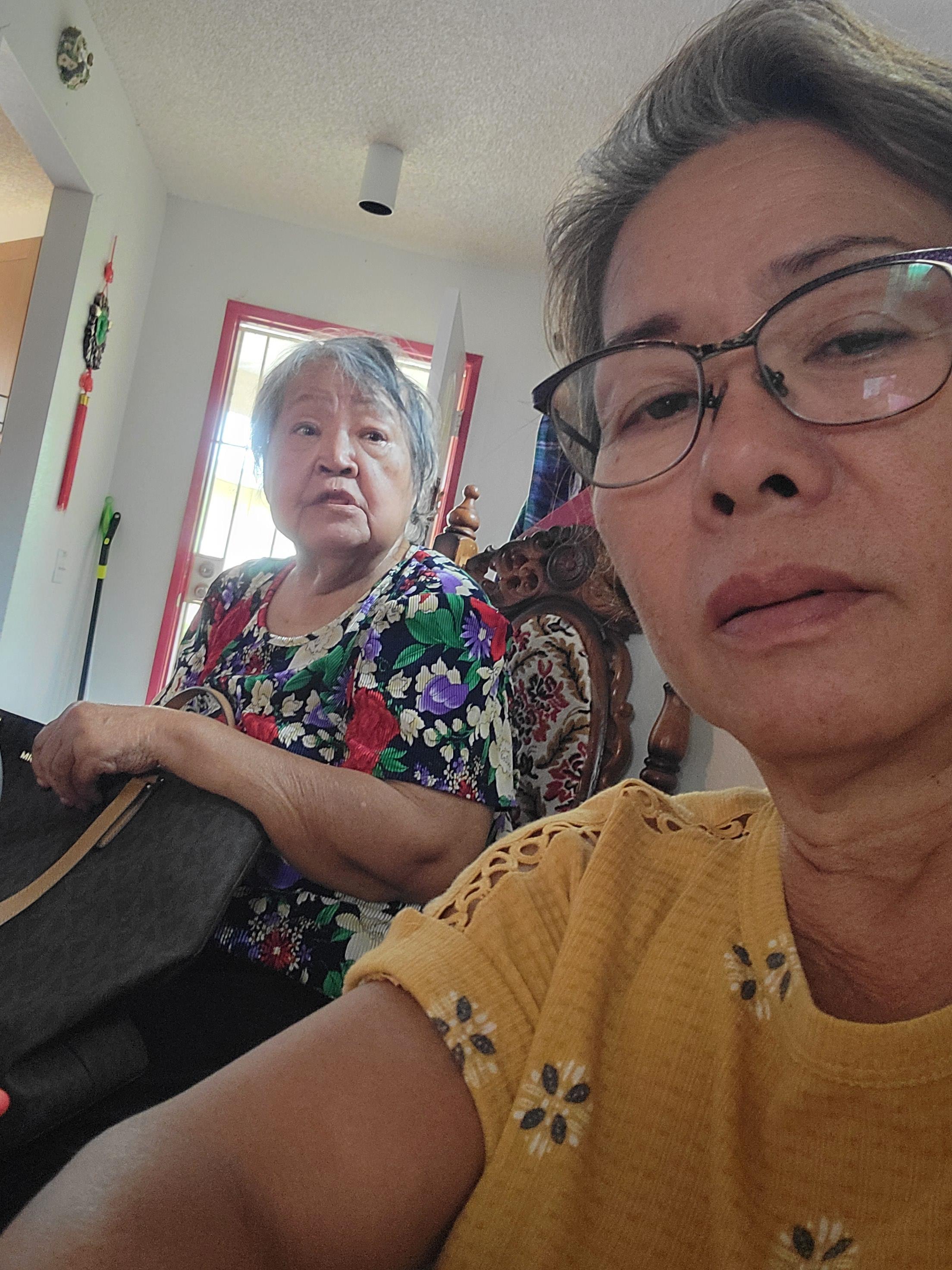 Two women share a moment in a charming, cozy indoor space filled with light.