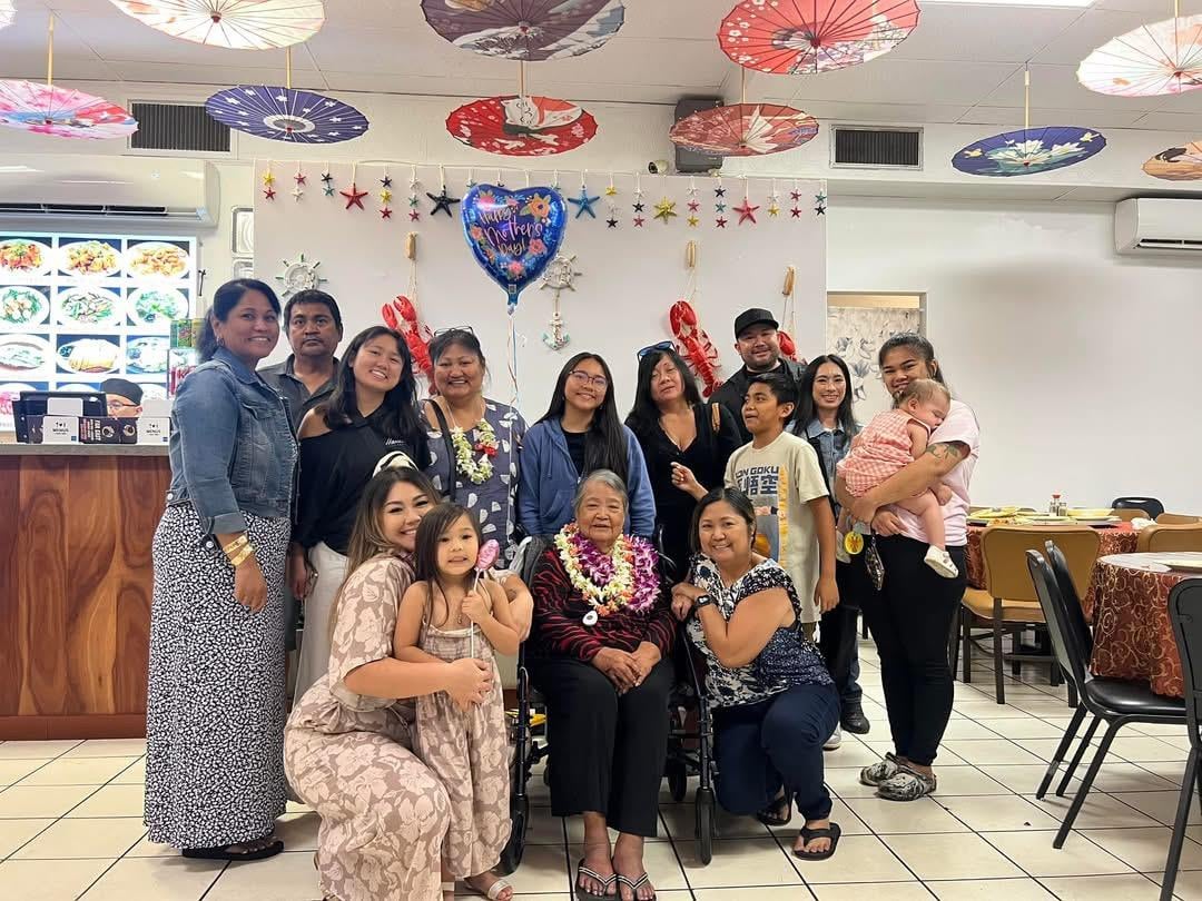 Group of women and children enjoying a joyful celebration in a decorated restaurant.