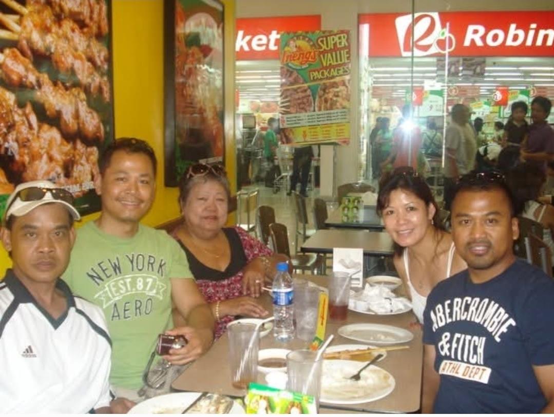 Group of friends enjoying lunch together at a busy restaurant during the afternoon.