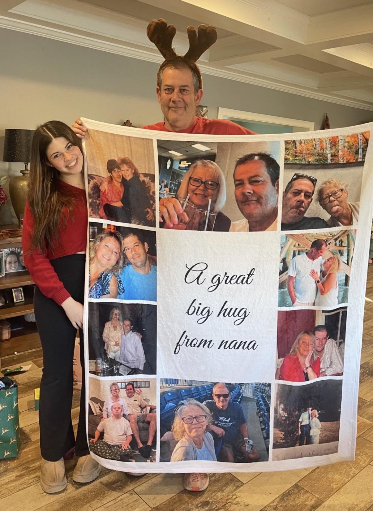 A man and woman holding a large blanket with a photo of a family
