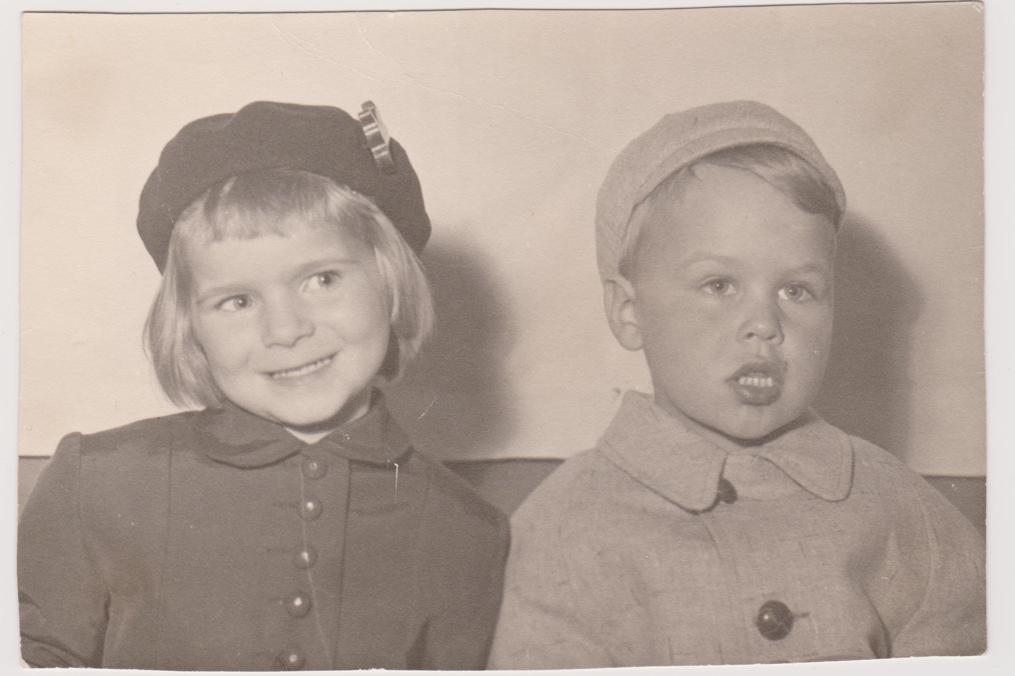 Children pose joyfully in matching outfits, showcasing their vintage hats and playful smiles.