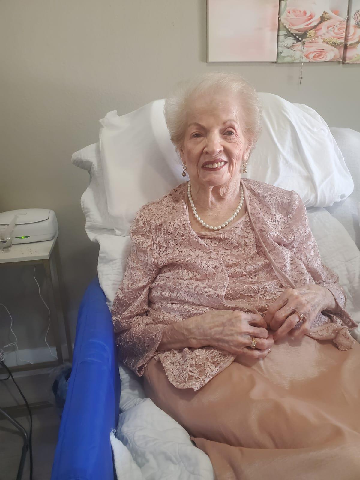 An elderly woman happily relaxes in a care home during the afternoon.