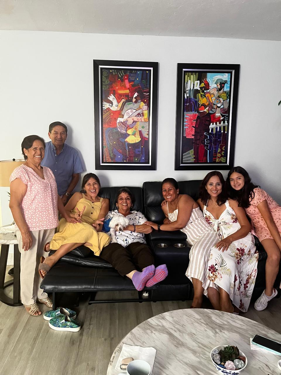 Several family members enjoy quality time together on a couch in a well-decorated living room.